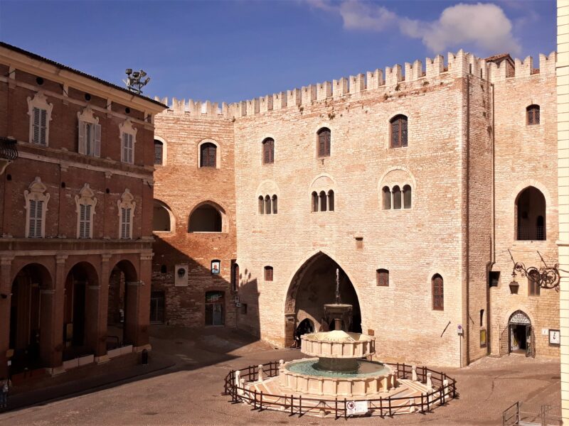 il palazzo del podestà di Fabriano e la fontana. Edificio quadrangolare, orlato da una merlatura ghibellina.