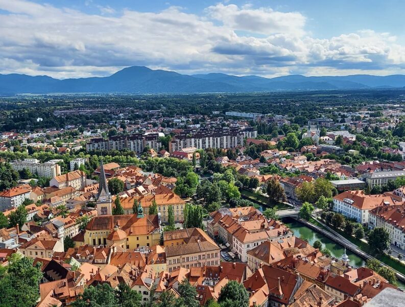Vista della capitale della Slovenia dall'alto: tra i tetti si scorge il campanile a punta della cattedrale e il fiume che attraversa la città.